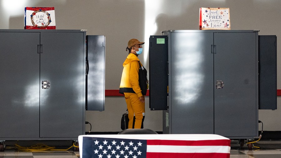 A person prepares to cast their ballot at a voting booth