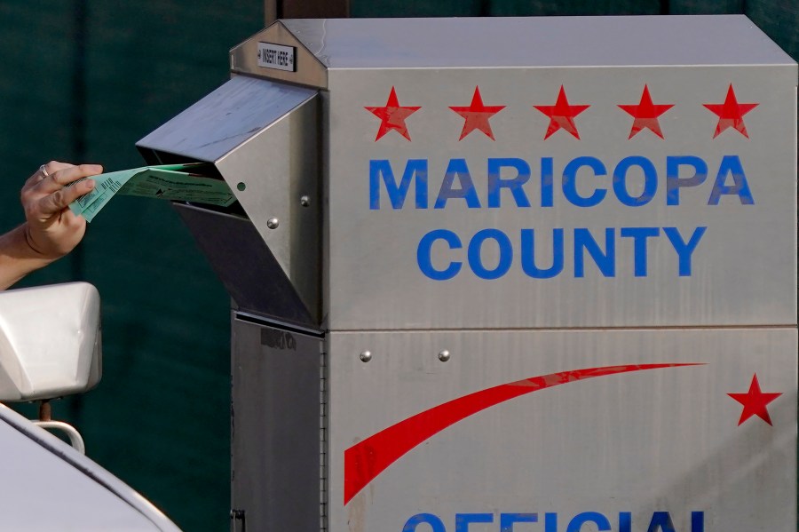 A voter casts their ballot at a secure ballot drop box at the Maricopa County Tabulation and Election Center