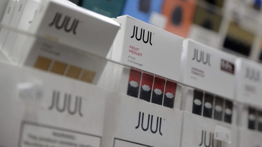 Juul products are displayed on a shelf.