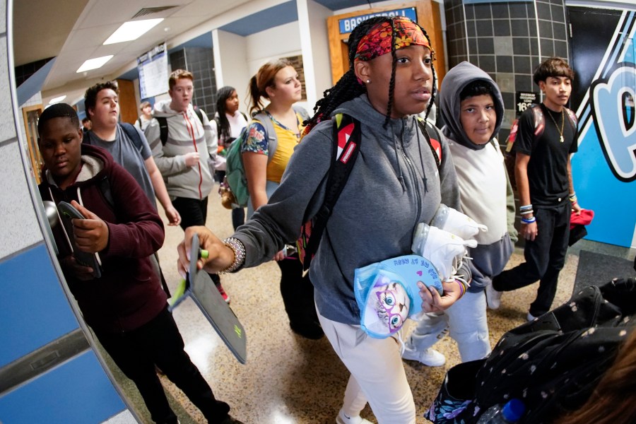 Students walk in the hallway of a school.