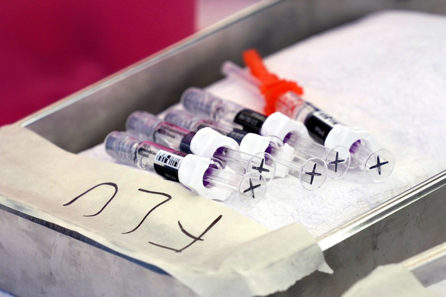 Syringes of the flu vaccine are lined up in a tray.