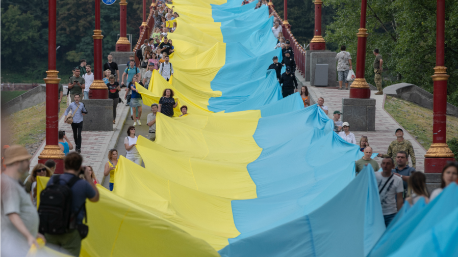 Activists hold a giant Ukrainian flag during an event "Ukraine united" in Kyiv, Ukraine, Sunday, Aug. 28, 2022. The action symbolises the unity of the Ukrainian people in the struggle for the independence of Ukraine. The 430-meter long flag connected both sides of Dnipro river. (AP Photo/Andrew Kravchenko)