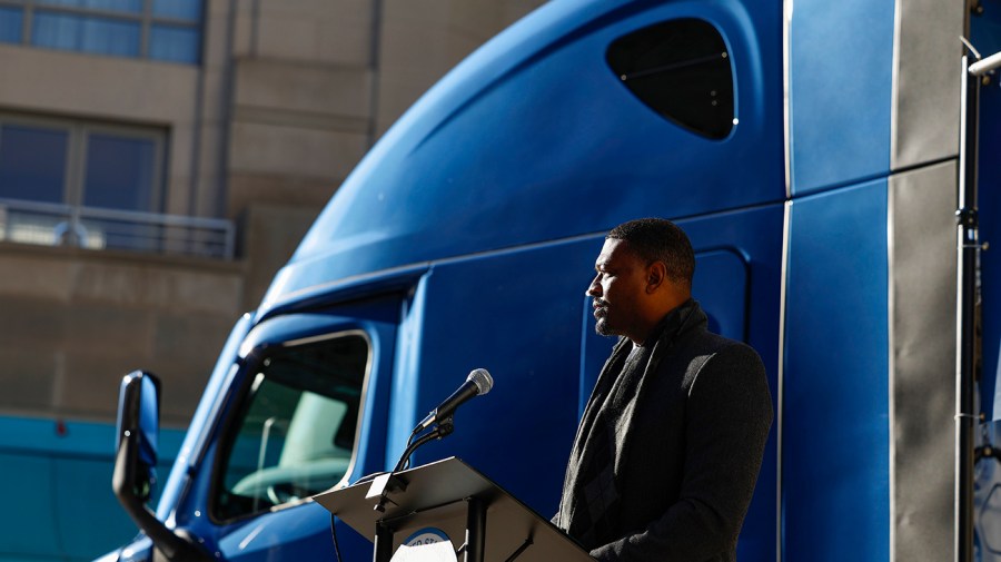 EPA Administrator Michael Regan speaks near a semitruck.