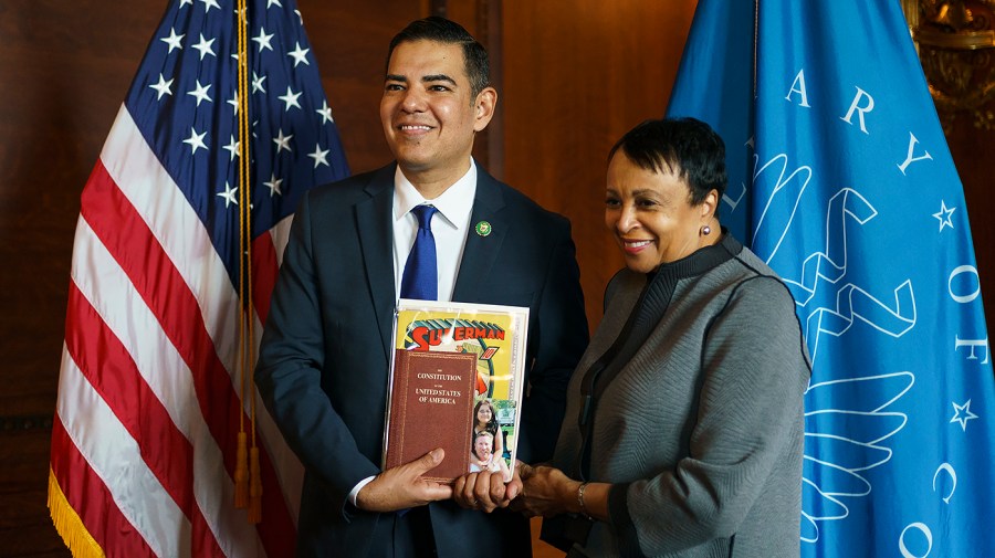 Rep. Robert Garcia (D-Calif.) poses with Librarian of Congress Dr. Carla Hayden and a copy of Superman #1, a Constitution, his immigration papers and photo of his late parents at the Library of Congress in Washington, D.C., on Thursday, January 12, 2023.