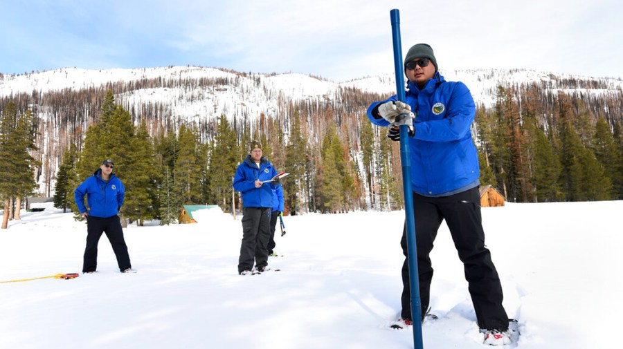 Individuals measuring snowpack in California