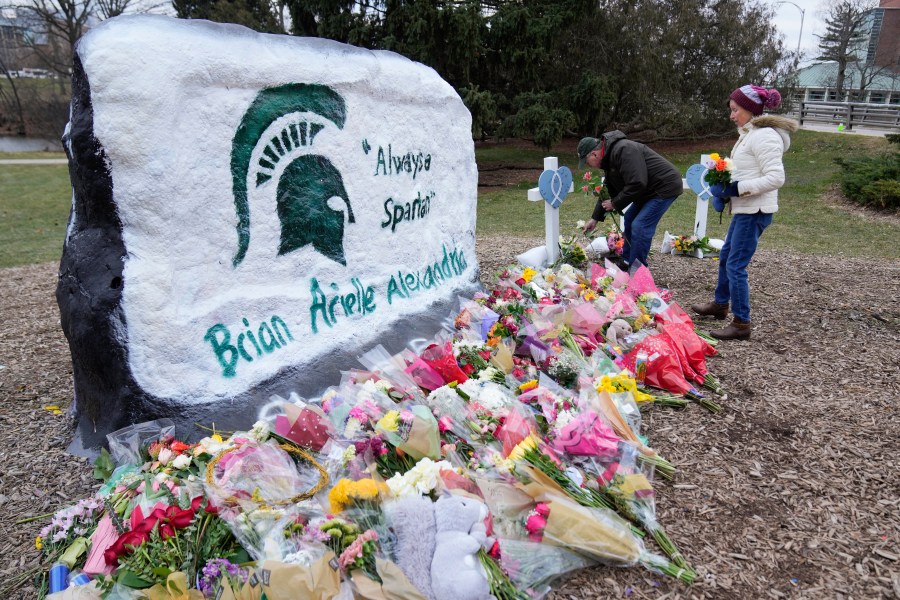 Mourners leave flowers at The Rock on the grounds of Michigan State University