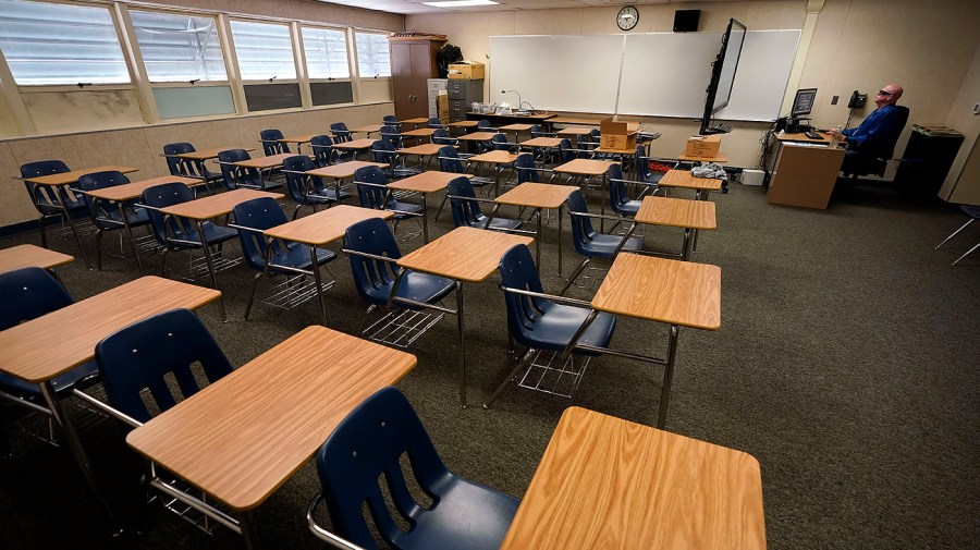 Math teacher Doug Walters sits among empty desks