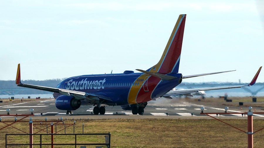 A Southwest Airlines Boeing 737-700 prepares for takeoff on an airport tarmac.