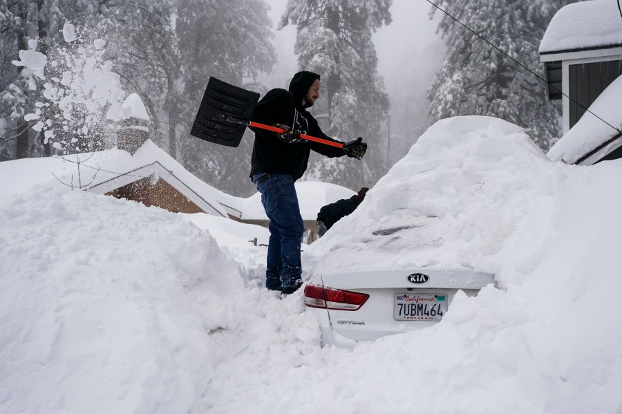 Kenny Rybak, 31, shovels snow around his car in Running Springs, Calif.