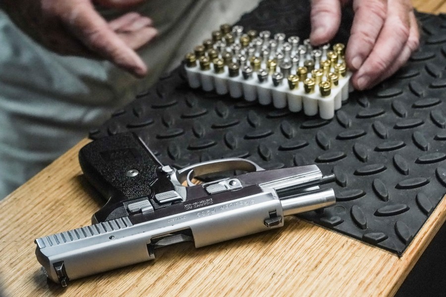 The owner of a shooting range prepares to load bullets in his 9mm semi-automatic handgun for a demonstration