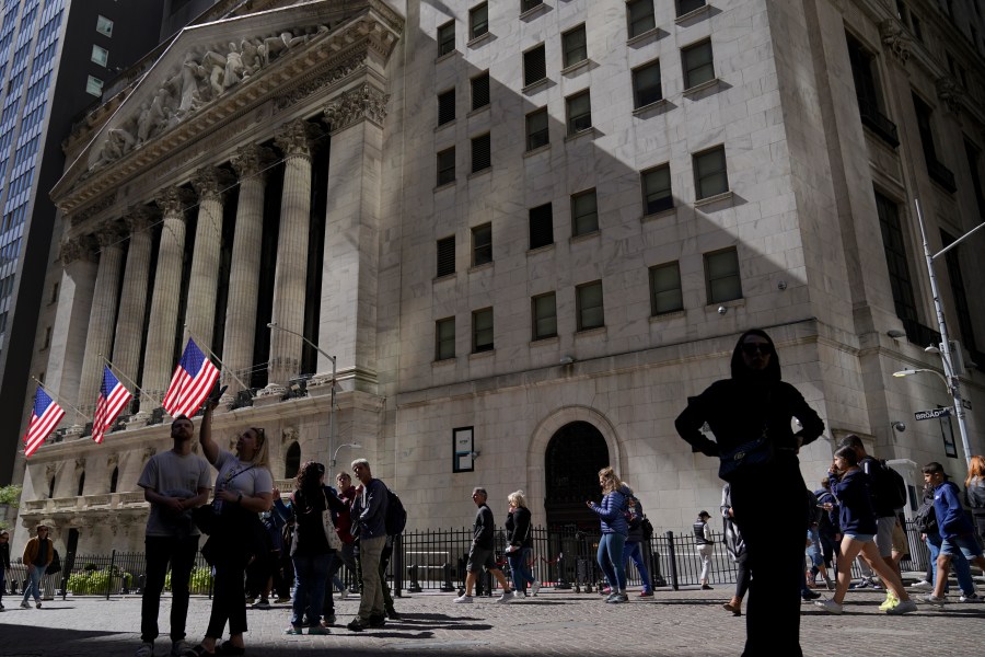 Visitors to the financial district walk past the New York Stock Exchange