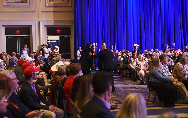 A protester with a speaker is escorted out as former President Trump speaks during the Conservative Political Action Conference (CPAC)