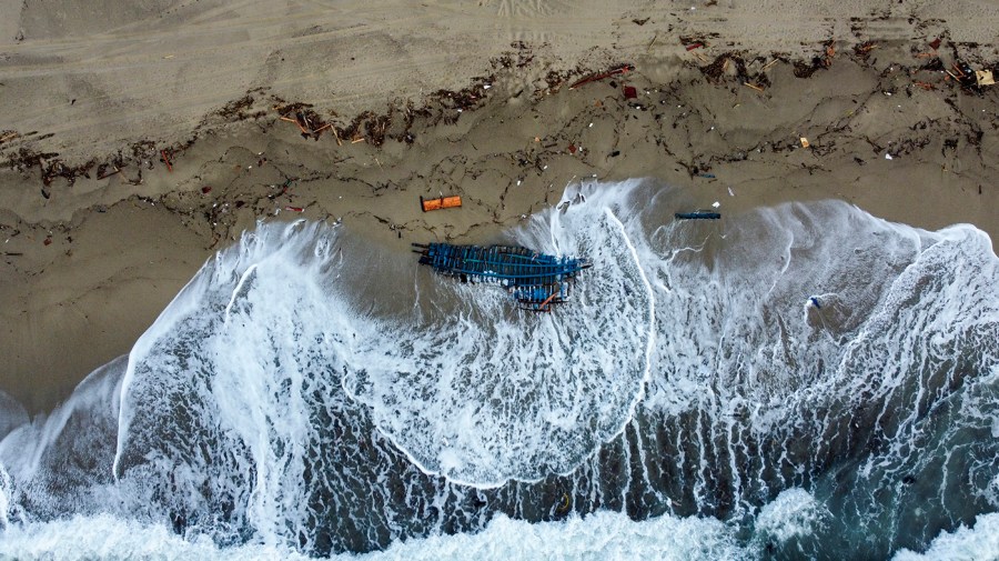 A view of part of the wreckage of a capsized boat that was washed ashore at a beach