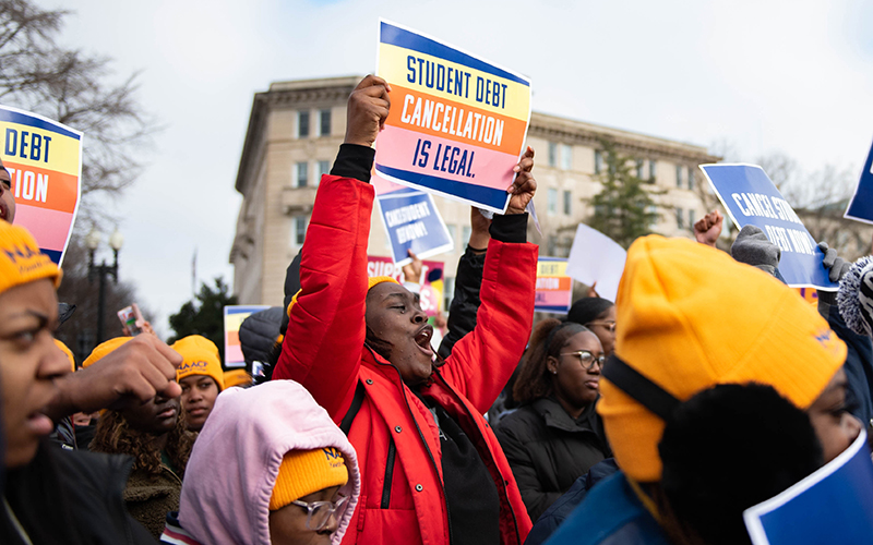 People in favor of President Biden’s student loan forgiveness plan rally in front of the Supreme Court