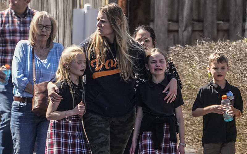 Children and adults depart the reunification center at the Woodmont Baptist Church after a school shooting on March 27 in Nashville, Tenn.