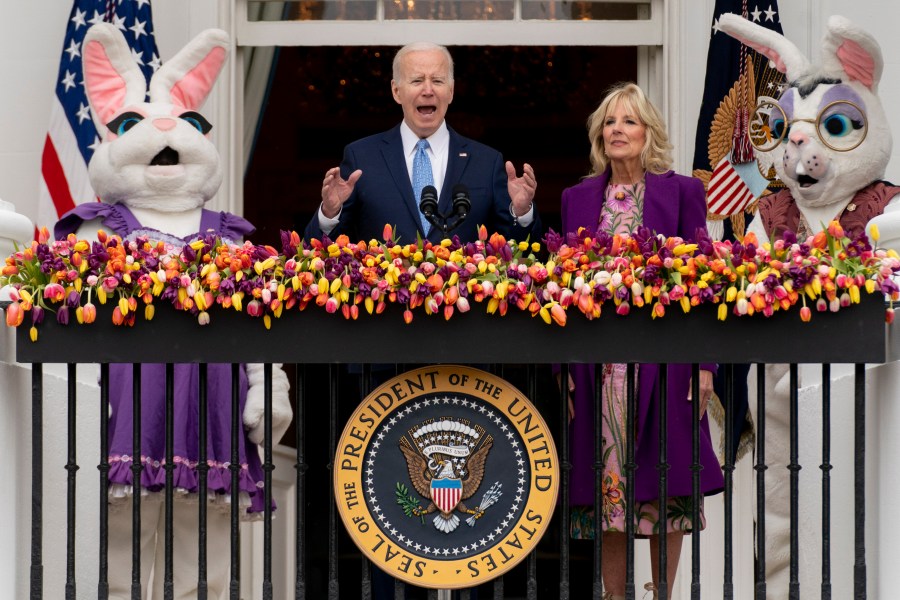 FILE - President Joe Biden, accompanied by first lady Jill Biden and Easter Bunnies, speaks on the Blue Room balcony at the White House during the White House Easter Egg Roll, April 18, 2022, in Washington. (AP Photo/Andrew Harnik, File)