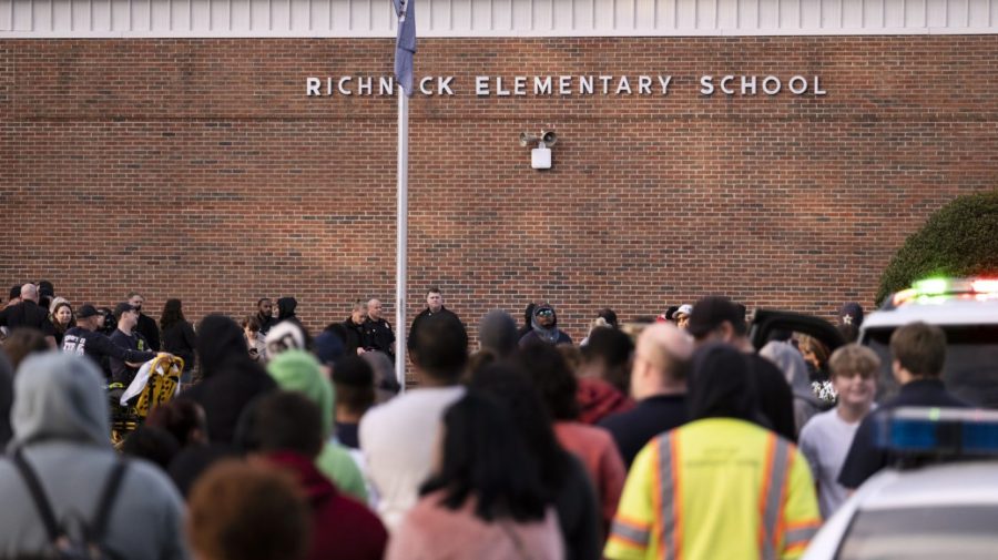 FILE - Students and police gather outside of Richneck Elementary School after a shooting, Jan. 6, 2023 in Newport News, Va. A Virginia teacher who was shot and seriously wounded by her 6-year-old student filed a lawsuit Monday, April 3, 2023, seeking $40 million in damages from school officials, accusing them of gross negligence and of ignoring multiple warnings the day of the shooting that the boy was armed and in a “violent mood.”(Billy Schuerman/The Virginian-Pilot via AP, File)