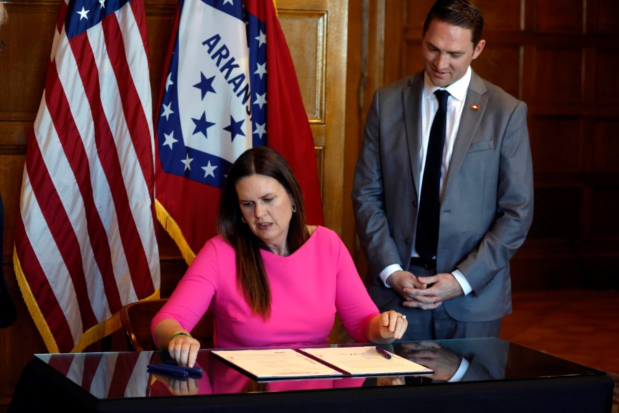 Gov. Sarah Huckabee Sanders signs a bill requiring age verification before creating a new social media account as Sen. Tyler Dees, R-Siloam Springs, looks on during a signing ceremony on Wednesday, April 12, 2023, at the state Capitol in Little Rock, Ark. (Thomas Metthe/Arkansas Democrat-Gazette via AP)