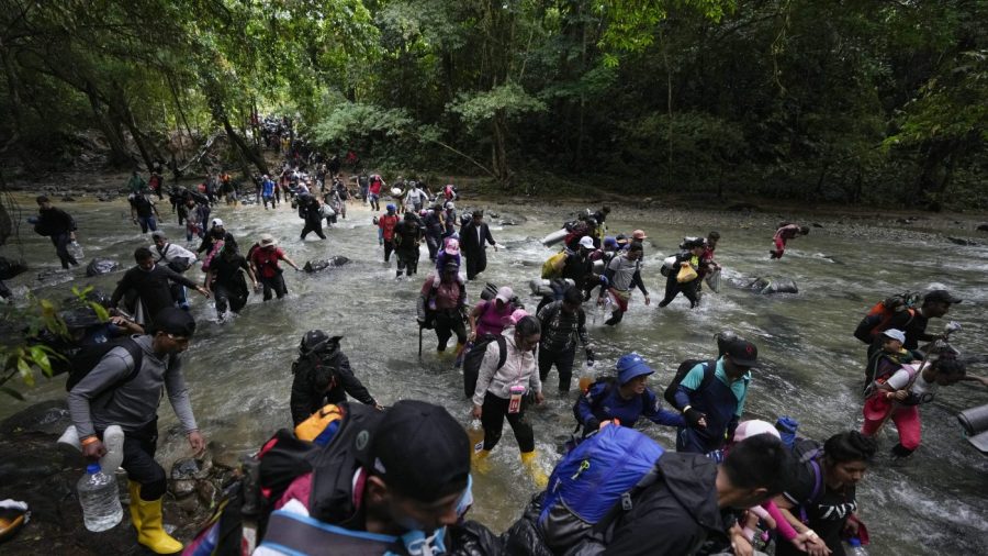 FILE - Migrants, mostly Venezuelans, cross a river during their journey through the Darien Gap from Colombia into Panama, hoping to reach the U.S., Oct. 15, 2022. (AP Photo/Fernando Vergara, File)