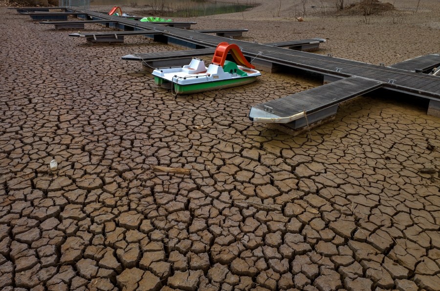 A pedal boat is tied to a dock in a dried part of the Sau reservoir, about 100 km (62 miles) north of Barcelona, Spain, Tuesday, April 18, 2023. Spain's prime minister warned fellow lawmakers Wednesday that the acute drought afflicting the country will become one of its leading long-term concerns. (AP Photo/Emilio Morenatti)