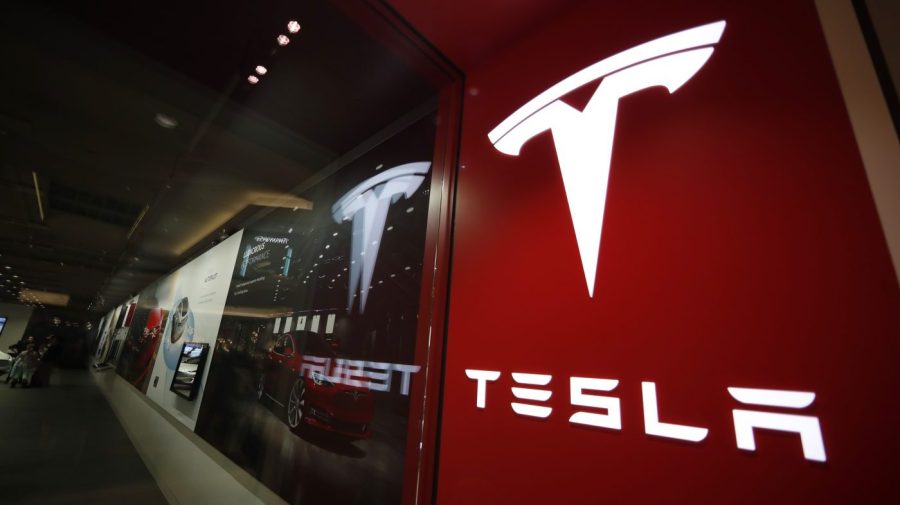 FILE - A sign bearing the Tesla company logo is displayed outside a Tesla store in Cherry Creek Mall in Denver, Colorado, Feb. 9, 2019. Tesla's first-quarter vehicle sales in 2023 rose 36% after the company cut prices twice in a bid to stimulate demand. (AP Photo/David Zalubowski, File)