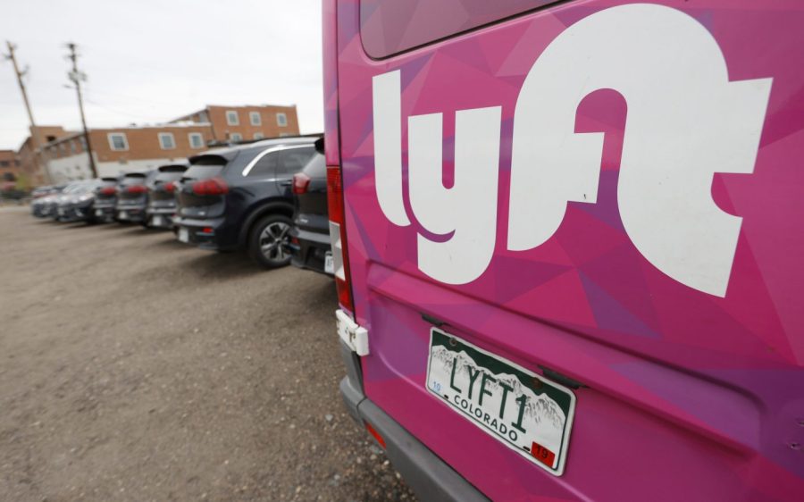 FILE - A Lyft ride-hailing vehicle is parked near Empower Field at Mile High in Denver on April 30, 2020. (AP Photo/David Zalubowski, File)