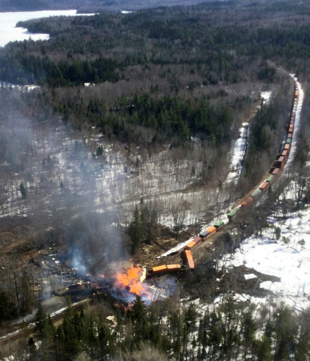 In this photo provided by the Maine Forest Service, several locomotives and rail cars burn after a freight train derailed Saturday, April 15, 2023, in Sandwich Academy Grant Township, near Rockwood, Maine. Three workers were treated and released from a hospital, and Canadian Pacific Railway will be leading the cleanup and track repair, according to officials. (Maine Forest Service via AP)