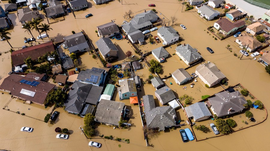 FILE - Floodwaters surround homes and vehicles in the community of Pajaro in Monterey County, Calif., March 13, 2023. An overwhelming majority of the U.S. public say they have recently experienced extreme weather, and most of them attribute that to climate change, according to a new poll from The Associated Press-NORC Center for Public Affairs Research. (AP Photo/Noah Berger)