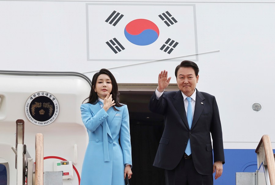 South Korean President Yoon Suk Yeol, right, waves as his wife Kim Keon Hee stands before departing for the United States at the Seoul military airport in Seongnam, South Korea, Monday, April 24, 2023. Yoon on Monday departed for Washington D.C. to meet with U.S. President Joe Biden. (Lim Hun-jung/Yonhap via AP)