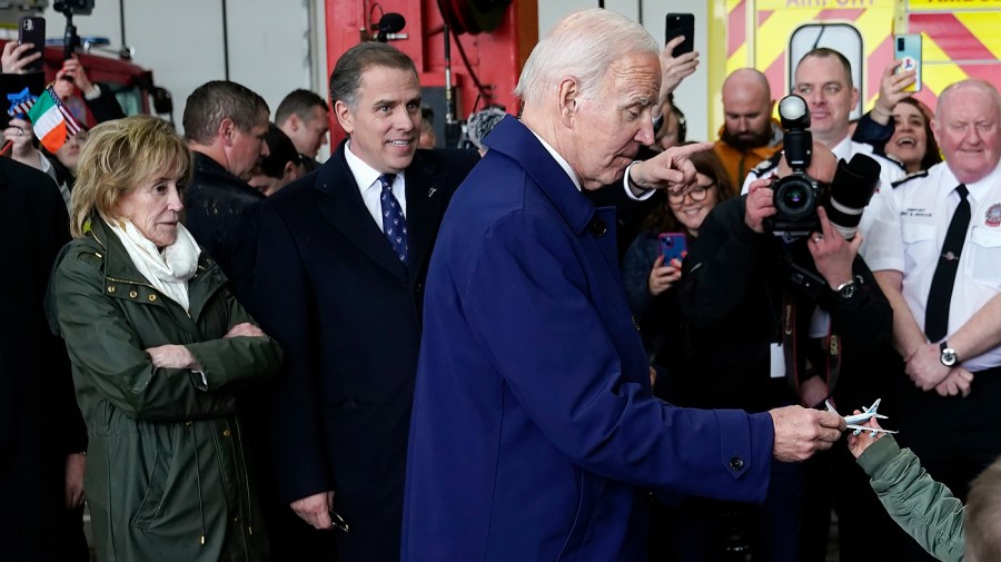 President Biden's sister Valerie Biden Owens, left, and son Hunter Biden look on as a child hands President Biden a toy Air Force One