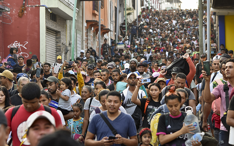 A street is crowded with migrants walking north on their way to Mexico City