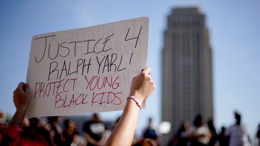 People gather at a rally to support Ralph Yarl while city hall stands in the distance, Tuesday, April 18, 2023, in Kansas City, Mo.