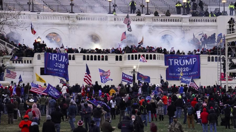 FILE - Violent insurrectionists loyal to President Donald Trump storm the Capitol, Jan. 6, 2021, in Washington. A Connecticut man who used a stolen riot shield to crush a police officer in a doorframe during the U.S. Capitol insurrection has been sentenced to more than seven years in prison for his role in one of the most violent episodes of the Jan. 6 attack. The sentence that a U.S. District Court judge imposed on 25-year-old Patrick McCaughey III on Friday, April 14, 2023, was approximately half the length of the prison term that prosecutors had recommended. (AP Photo/John Minchillo, File)