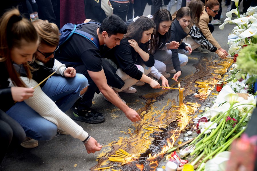 School children light candles near the Vladislav Ribnikar school in Belgrade, Serbia, Thursday, May 4, 2023. Many wearing black and carrying flowers, scores of Serbian students on Thursday paid silent homage to their peers killed a day earlier when a 13-year-old boy used his father’s guns in a school shooting rampage that sent shock waves through the nation and triggered moves to boost gun control. (AP Photo/Armin Durgut)