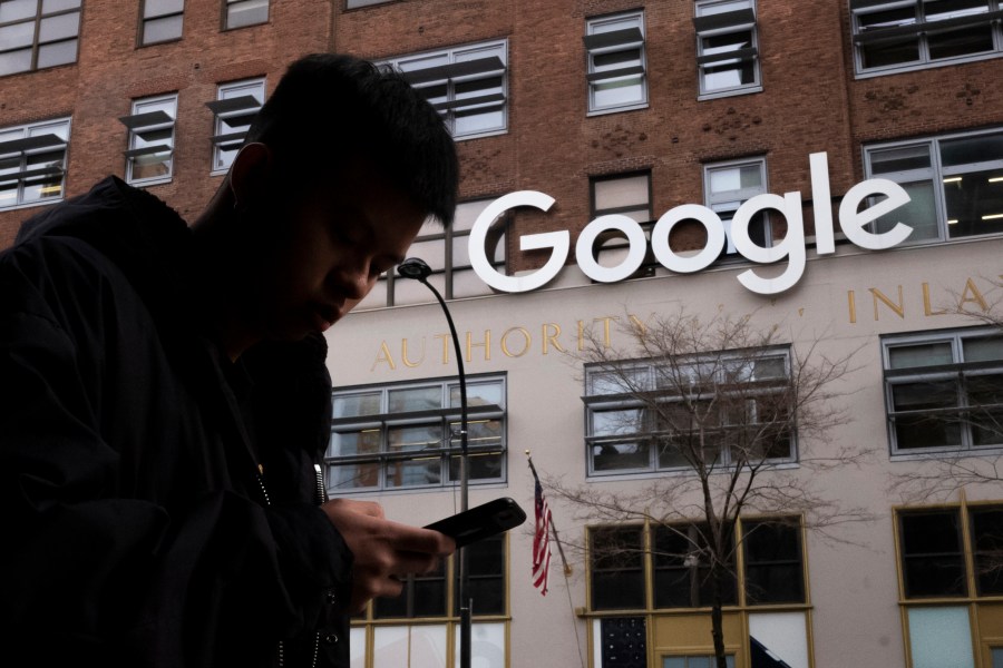 FILE - A man using a cell phone walks past Google offices on Dec. 17, 2018, in New York.