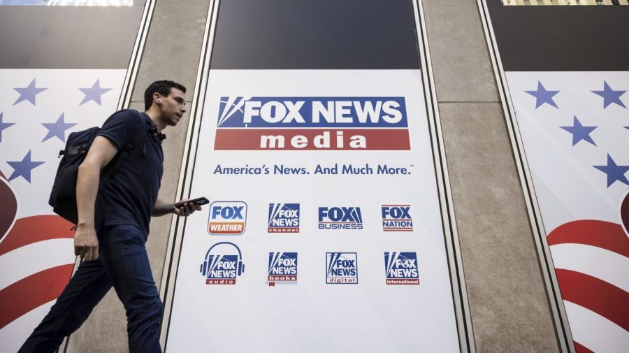 FILE - A person walks past the Fox News Headquarters in New York on April 12, 2023. Fox Corp. swung to a third quarter loss Tuesday, May 9, weighed down by Fox News' nearly $800 million settlement with Dominion Voting Systems. (AP Photo/Yuki Iwamura, File)