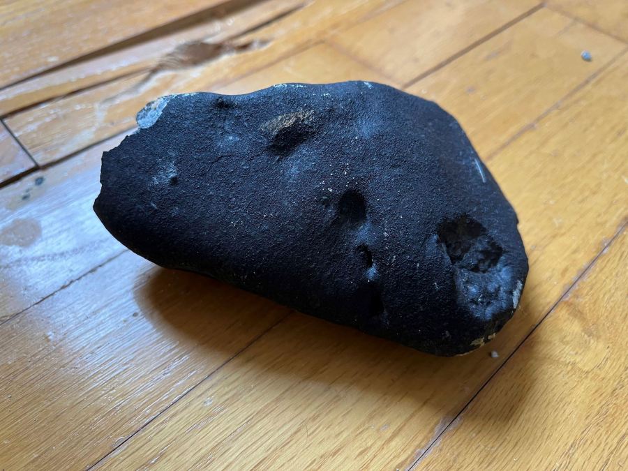 This image provided by Hopewell Township Police Department shows a metallic object believed to be a meteorite that struck the roof a residence in Hopewell Township, N.J. Hopewell Township police said the 4- by-6-inch, oblong-shaped object struck the ranch-style home on Monday, May 8, 2023 and eventually came to rest on a floor. It's estimated to weigh about four pounds. (Hopewell Township Police Department via AP)