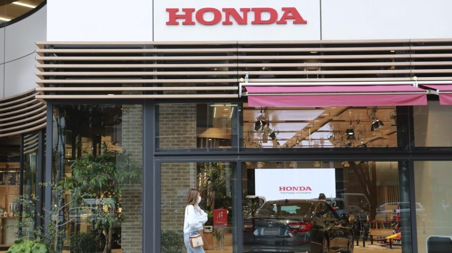 A woman walks past the logo of Honda Motor Co. in Tokyo on Oct. 19, 2021. Honda’s profit for the fiscal year that ended in March dropped 1.7% as sales took a hit from a semiconductor shortage and restrictions in China related to the coronavirus pandemic. But the Japanese automaker said Thursday, May 11, 2023, that recovery was on the way, forecasting record sales and operating profitability for the current fiscal year. (AP Photo/Koji Sasahara)