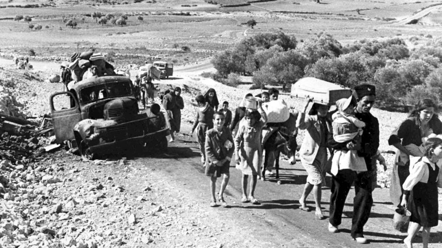 FILE - A group of Arab refugees walks along a road from Jerusalem to Lebanon, carrying their belongings with them on Nov. 9, 1948. The group was driven from their homes by attacks in Galilee. For the first time, the United Nations will officially commemorate the flight of hundreds of thousands of Palestinians from what is now Israel on the 75th anniversary of their exodus, an action stemming from the U.N.’s partition of British-ruled Palestine into separate Jewish and Arab states. (AP Photo/Jim Pringle, File)