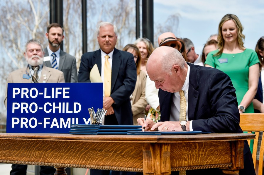 Montana Gov. Greg Gianforte (R) signs a suite of bills aimed at restricting access to abortion during a bill signing ceremony on the steps of the state Capitol in Helena, Mont., May 3, 2023.