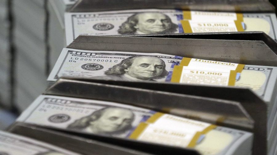 FILE - Cut stacks of $100 bills make their way down the line at the Bureau of Engraving and Printing Western Currency Facility in Fort Worth, Texas, Sept. 24, 2013. All the hand-wringing over a potential government default if Congress doesn’t increase the national debt limit has conjured up images of past government shutdowns. In fact, there’s a big difference between a government default and a government shutdown. A default would occur if the government exceeds its legal borrowing limit and can no longer pay all its creditors or pay for existing programs. (AP Photo/LM Otero, File)