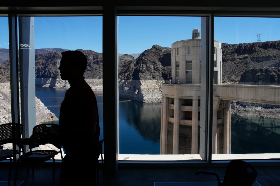 FILE - People attend a news conference on Lake Mead at Hoover Dam, April 11, 2023, near Boulder City, Nev. Arizona, California and Nevada on Monday, May 22, proposed a deal to significantly cut their water use from the drought-stricken Colorado River over the next three years. (AP Photo/John Locher, File)