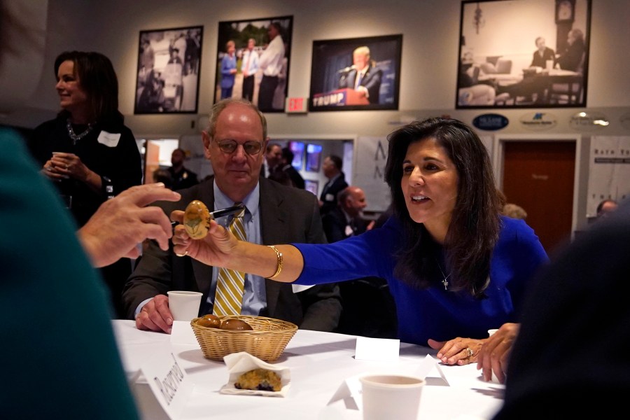 Republican presidential candidate Nikki Haley passes an autographed wooden egg to a guest during a breakfast gathering at Saint Anselm College, Wednesday, May 24, 2023, in Manchester, N.H. (AP Photo/Charles Krupa)