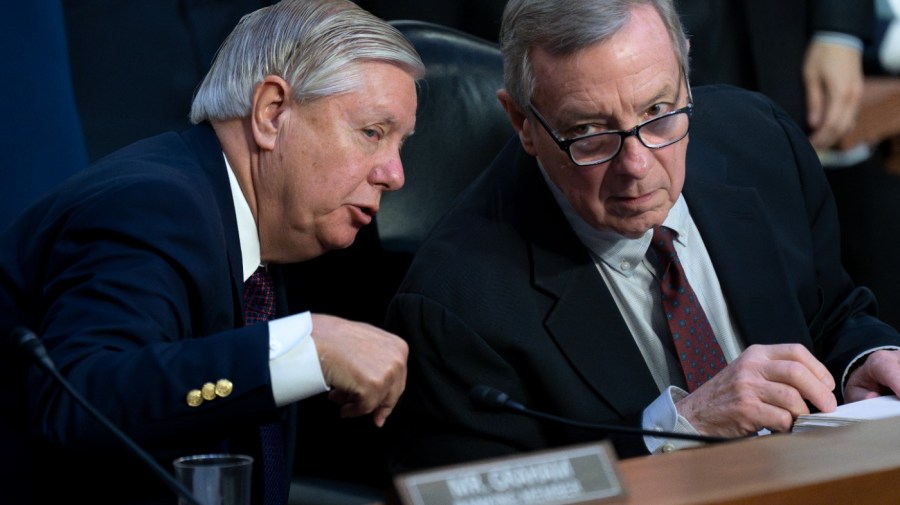 Senator Lindsey Graham leans over to speak with Senator Dick Durbin during a congressional hearing.