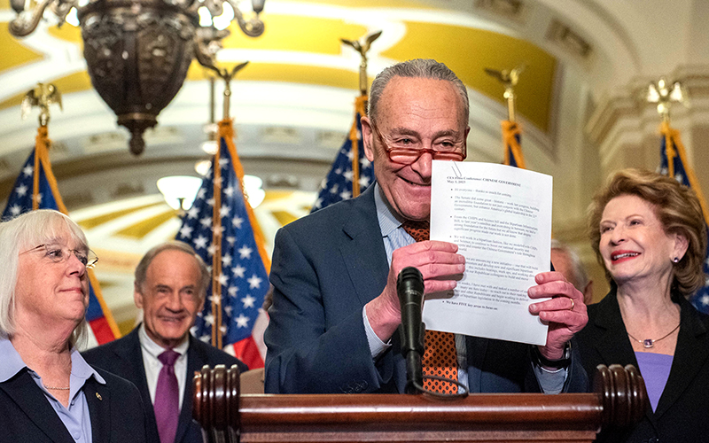 Majority Leader Chuck Schumer (D-N.Y.) holds up his notes during a press conference