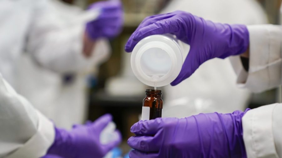 FILE - Eva Stebel, water researcher, pours a water sample into a smaller glass container for experimentation as part of drinking water and PFAS research at the U.S. Environmental Protection Agency Center For Environmental Solutions and Emergency Response on Feb. 16, 2023, in Cincinnati. Three chemical companies said Friday, June 2, 2023, that they had reached a $1.18 billion deal to resolve complaints of polluting many U.S. drinking water systems with potentially harmful compounds known as PFAS. (AP Photo/Joshua A. Bickel, File)