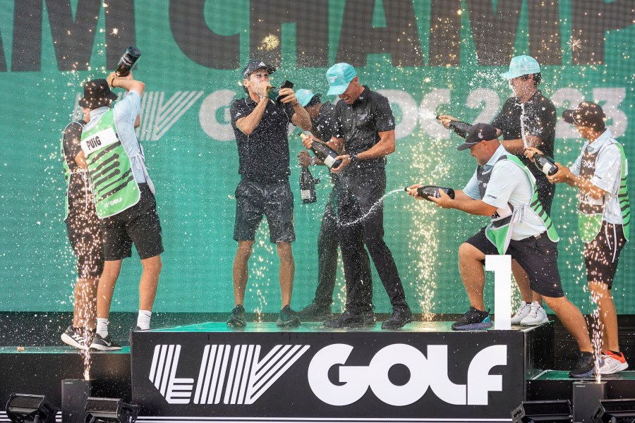 Team champions David Puig, Sebastián Muñoz, Mito Pereira, Captain Joaquín Niemann of Torque GC and their caddies celebrate on stage with the team trophy during LIV Golf DC at the Trump National Golf Club in Washington Sunday, May 28, 2023, in Sterling, Virginia.