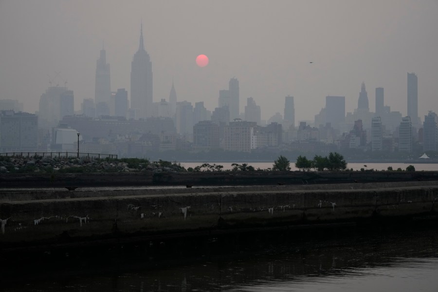 The sun rises over a hazy New York City skyline as seen from Jersey City, N.J., Wednesday, June 7, 2023. Intense Canadian wildfires are blanketing the northeastern U.S. in a dystopian haze, turning the air acrid, the sky yellowish gray and prompting warnings for vulnerable populations to stay inside. (AP Photo/Seth Wenig)