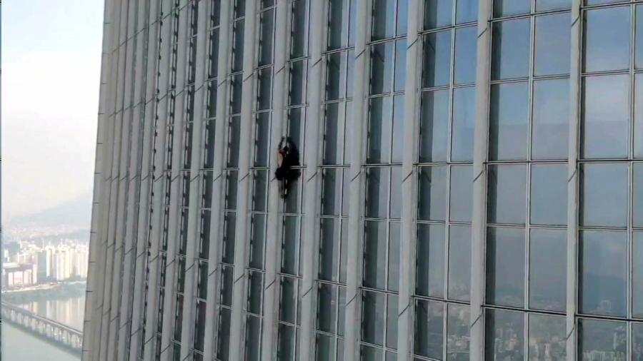 This photo provided by the Seoul Metropolitan Fire and Disaster Management Headquarters, shows an unidentified British man climbing Lotte World Tower, the tallest skyscraper in the country, in Seoul, South Korea, Monday, June 12, 2023. The British man was detained after climbing more than half way up the world’s fifth-tallest skyscraper in Seoul with only his bare hands on Monday, authorities said. (The Seoul Metropolitan Fire and Disaster Management Headquarters, via AP).