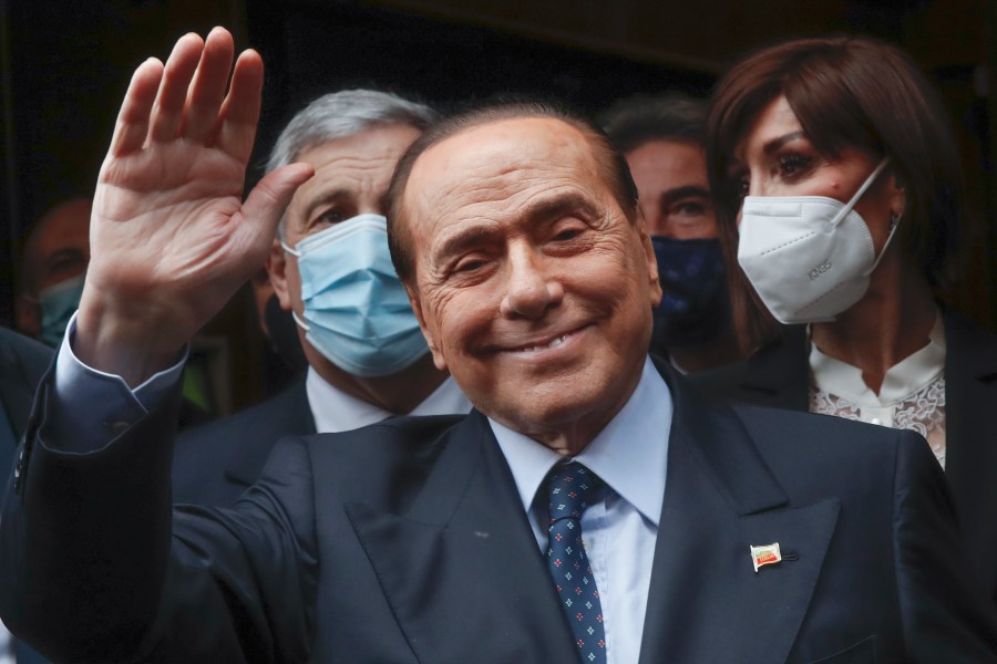 FILE - Former Italian Premier Silvio Berlusconi waves to reporters as he arrives at the Chamber of Deputies to meet Mario Draghi, in Rome, Feb. 9, 2021. Berlusconi, the boastful billionaire media mogul who was Italy's longest-serving premier despite scandals over his sex-fueled parties and allegations of corruption, died, according to Italian media. He was 86. (AP Photo/Alessandra Tarantino, File)